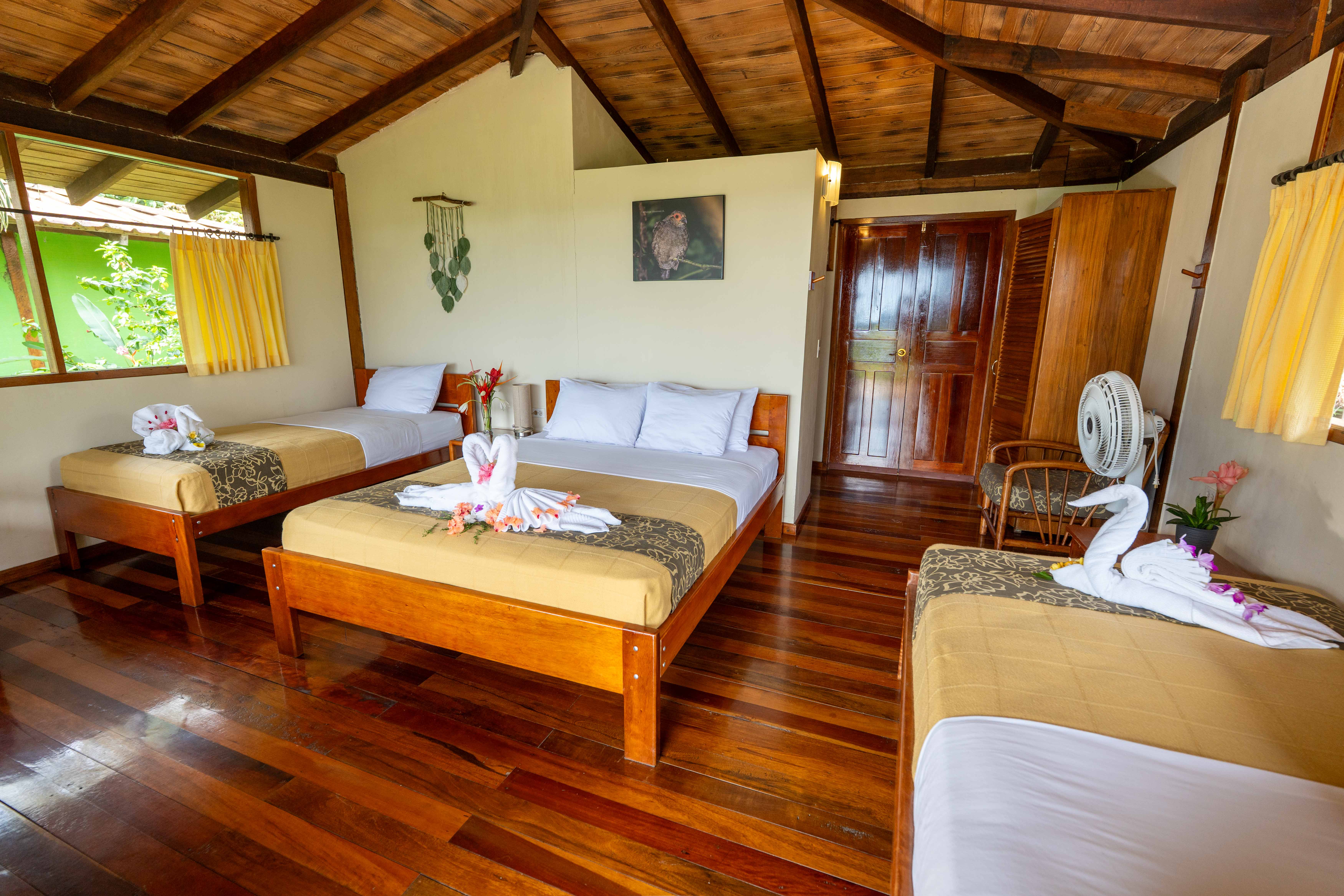Interior de cabaña familiar triple con camas y acabados en madera de Yachana Lodge
