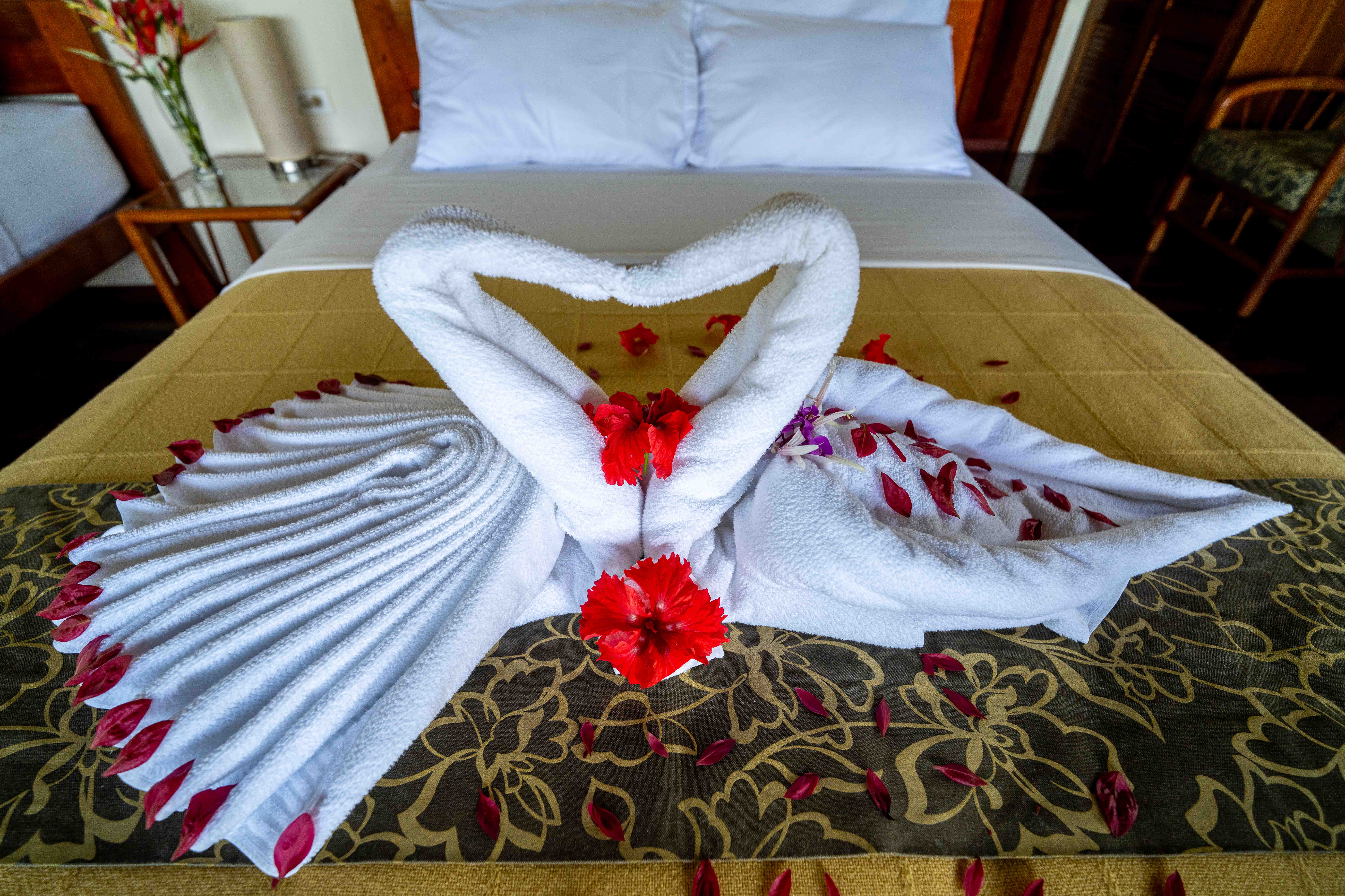 Decoración especial de habitación con toallas en forma de cisne y flores en Yachana Lodge