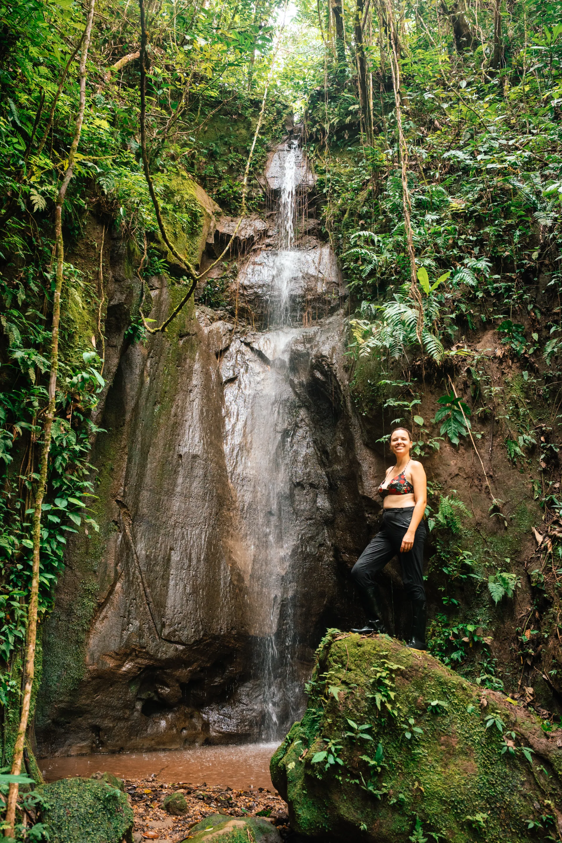 Turista posando junto a una cascada natural en la selva de Yachana Lodge